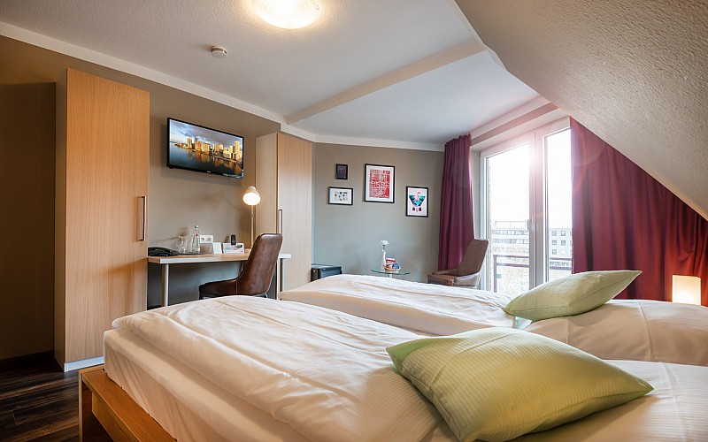 Helles und modernes Hotelzimmer mit Doppelbett und Schreibtisch – zentral gelegen in Geilenkirchen